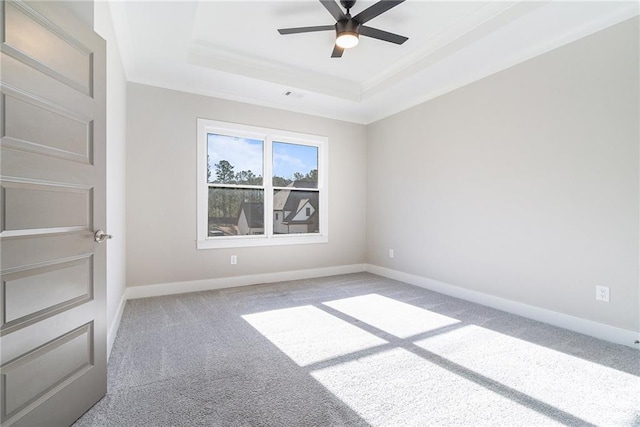 carpeted spare room with baseboards, visible vents, a tray ceiling, and ceiling fan