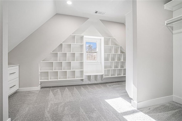 additional living space featuring carpet flooring, visible vents, built in features, vaulted ceiling, and baseboards