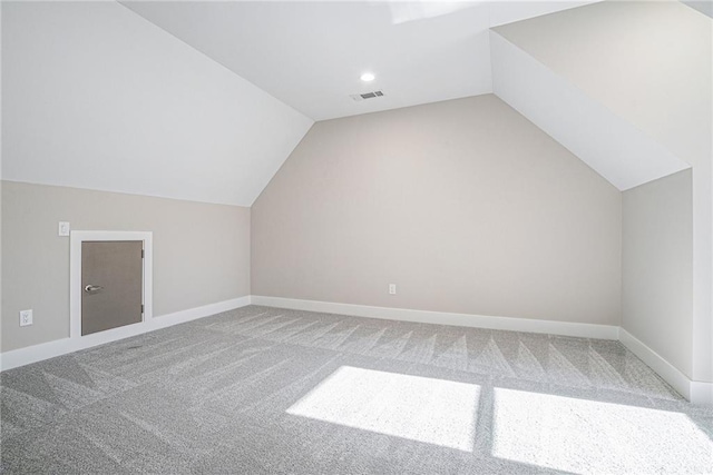 additional living space with lofted ceiling, baseboards, visible vents, and carpet flooring