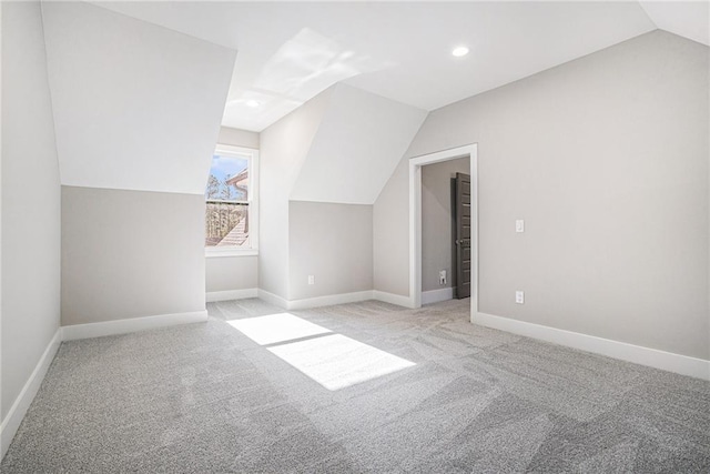 additional living space with recessed lighting, light carpet, vaulted ceiling, and baseboards