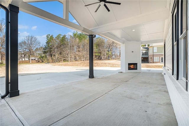 view of patio / terrace featuring a ceiling fan and a large fireplace