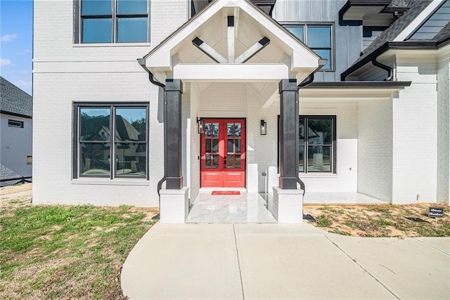 doorway to property featuring french doors and brick siding