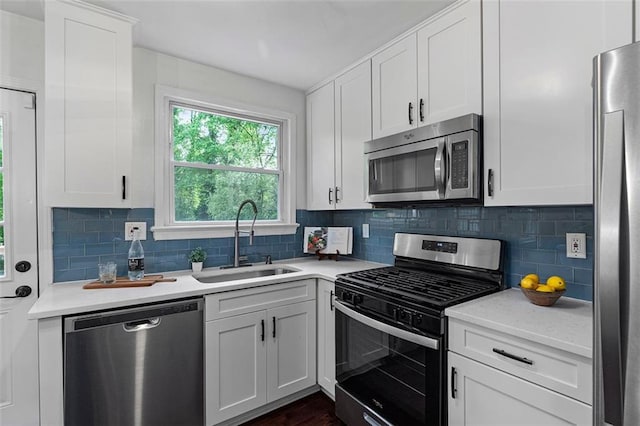 kitchen featuring a sink, backsplash, stainless steel appliances, and light countertops