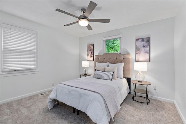carpeted bedroom with baseboards, visible vents, and a ceiling fan