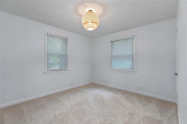unfurnished room with visible vents, carpet floors, and baseboards