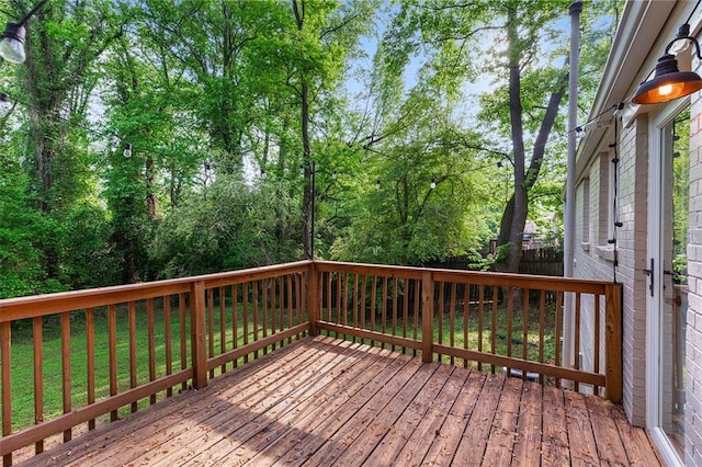 wooden terrace featuring a lawn and a fenced backyard