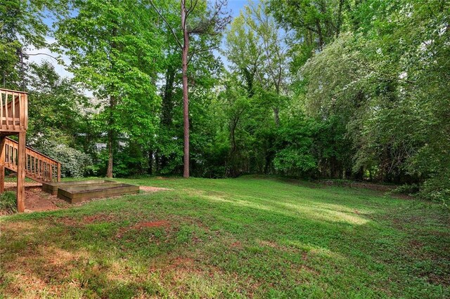 view of yard with a wooden deck and stairway