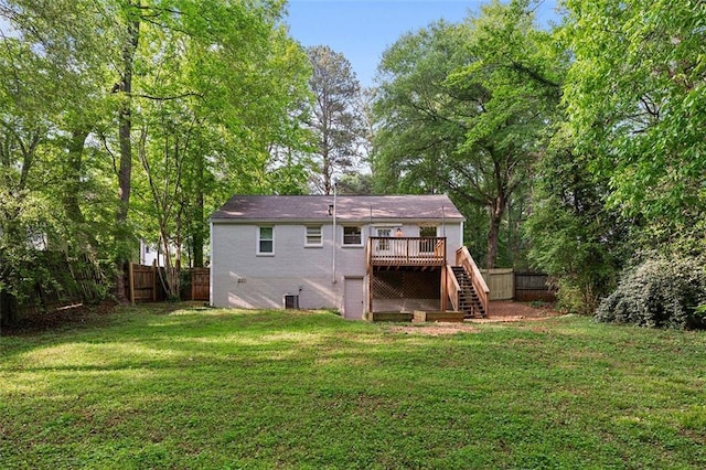 back of house with a deck, a fenced backyard, a yard, and stairs