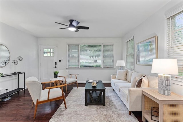 living area with baseboards, wood finished floors, and a ceiling fan