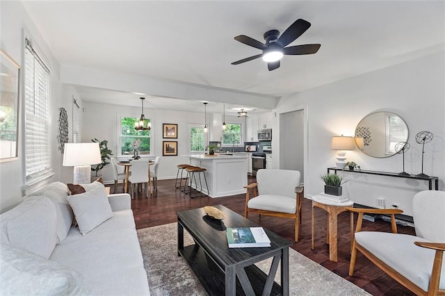 living room with dark wood-style floors, baseboards, and a ceiling fan