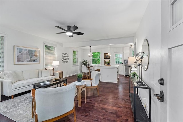 living room featuring a ceiling fan, a healthy amount of sunlight, and dark wood-style flooring