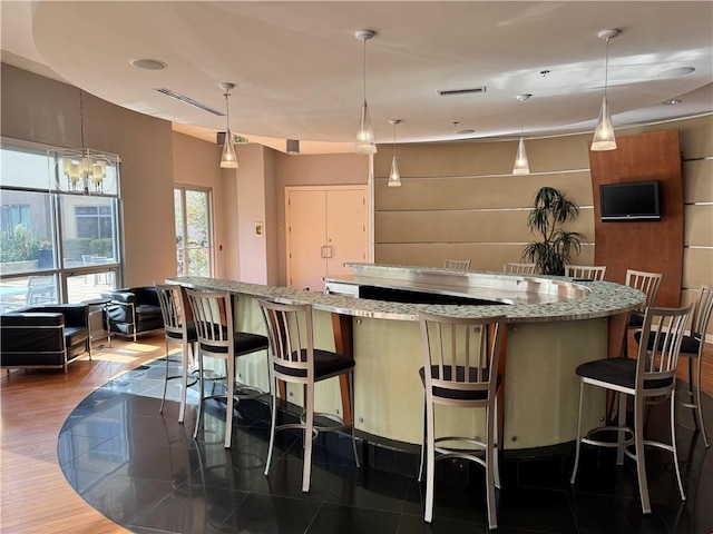 711 Cosmopolitan Dr NE Unit 426, Atlanta, GA 30324 - kitchen featuring a spacious island, light stone counters, decorative light fixtures, and a breakfast bar area
