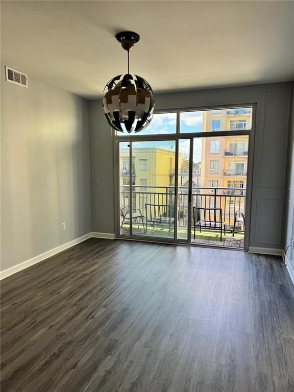 711 Cosmopolitan Dr NE Unit 426, Atlanta, GA 30324 - spare room with a chandelier, dark wood-type flooring, and baseboards