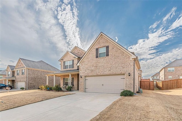 traditional-style home with driveway, an attached garage, fence, and brick siding