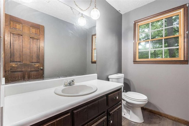 6230 S Summers Cir S, Douglasville, GA 30135 - bathroom featuring wood finished floors, toilet, vanity, a textured ceiling, and baseboards