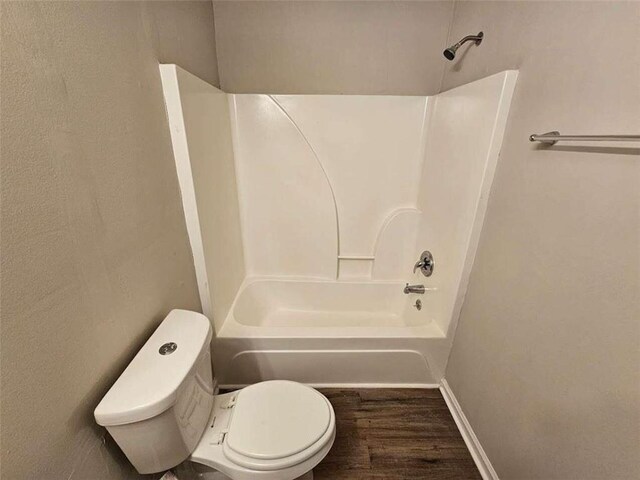6500 Wellington Chase Ct, Lithonia, GA 30058 - bathroom featuring toilet, shower / bathtub combination, baseboards, and wood finished floors