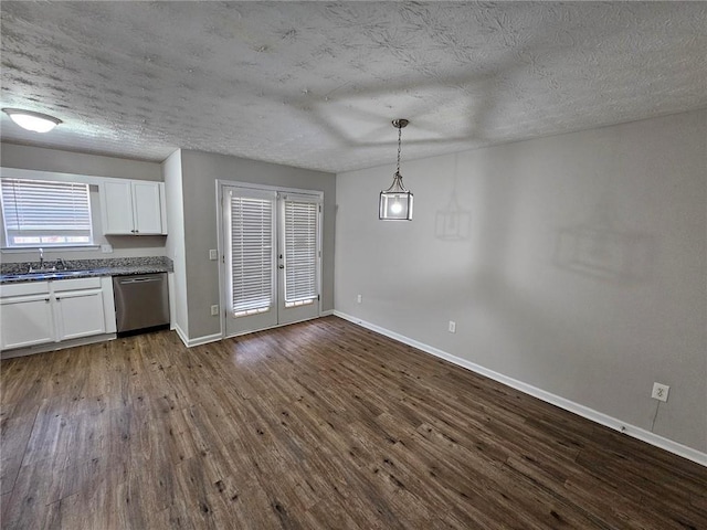 6500 Wellington Chase Ct, Lithonia, GA 30058 - unfurnished dining area with baseboards, french doors, dark wood-style floors, a textured ceiling, and a sink