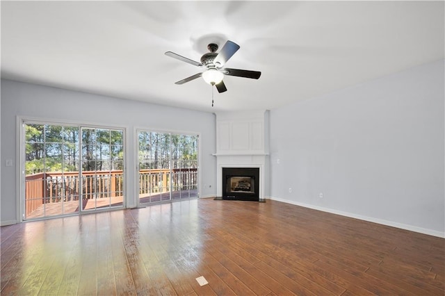 unfurnished living room with ceiling fan, wood finished floors, and a fireplace