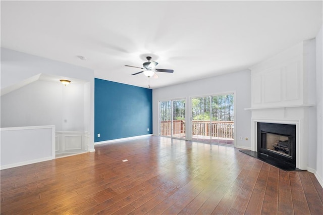 unfurnished living room featuring wood finished floors, a ceiling fan, and a fireplace