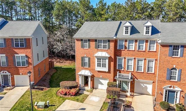 view of property with brick siding, a front lawn, driveway, and an attached garage