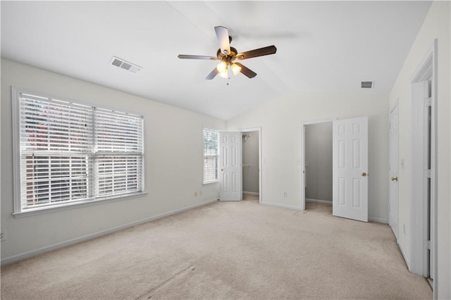 unfurnished bedroom with lofted ceiling, carpet, visible vents, and baseboards