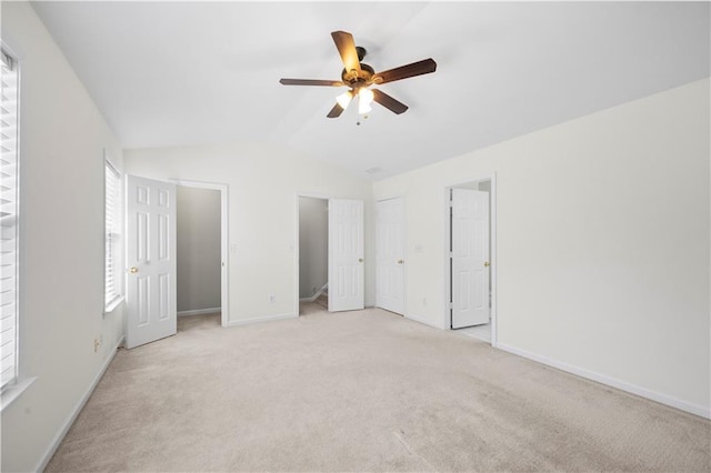 unfurnished bedroom featuring baseboards, ceiling fan, light colored carpet, and lofted ceiling