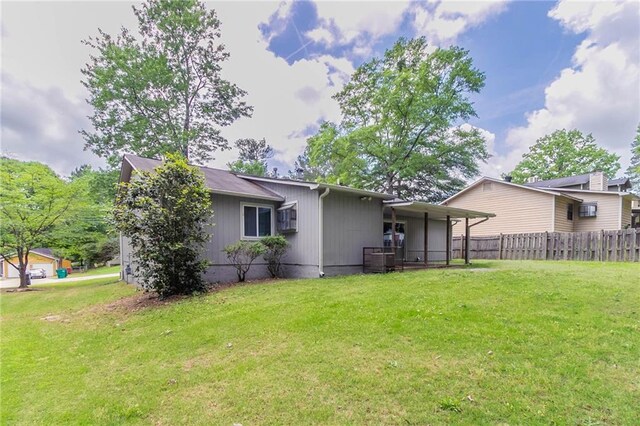 rear view of property featuring a yard and fence