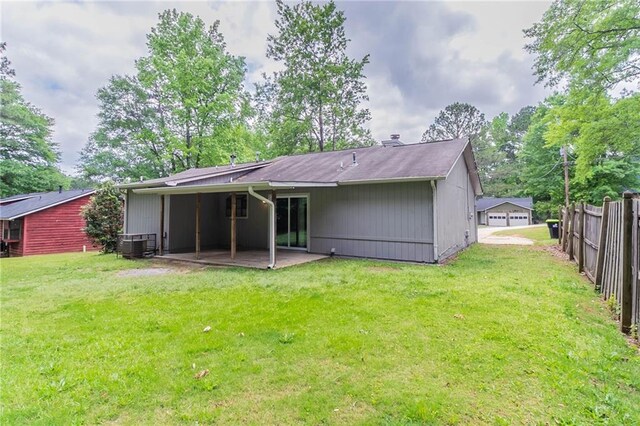 rear view of property with a lawn, fence, central AC unit, and a patio area