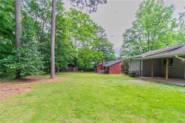 view of yard featuring central air condition unit and a carport