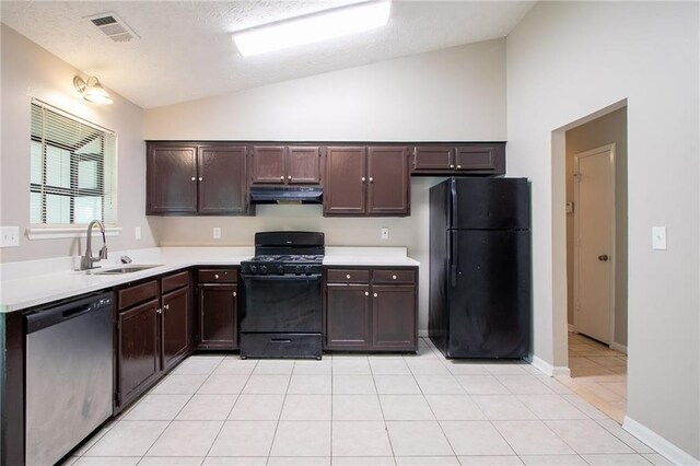kitchen with a sink, light countertops, under cabinet range hood, visible vents, and black appliances