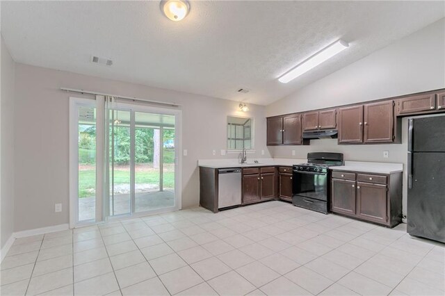 kitchen featuring light countertops, lofted ceiling, under cabinet range hood, visible vents, and black appliances