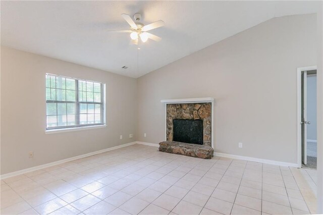 unfurnished living room with a stone fireplace, ceiling fan, lofted ceiling, and light tile patterned floors