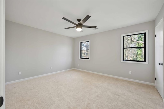 carpeted empty room featuring visible vents, baseboards, and ceiling fan