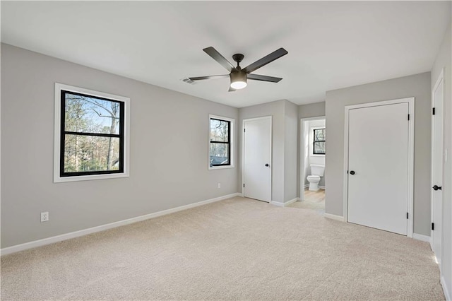 unfurnished bedroom with light colored carpet and baseboards