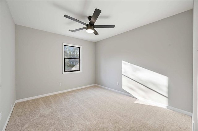 carpeted empty room with a ceiling fan and baseboards