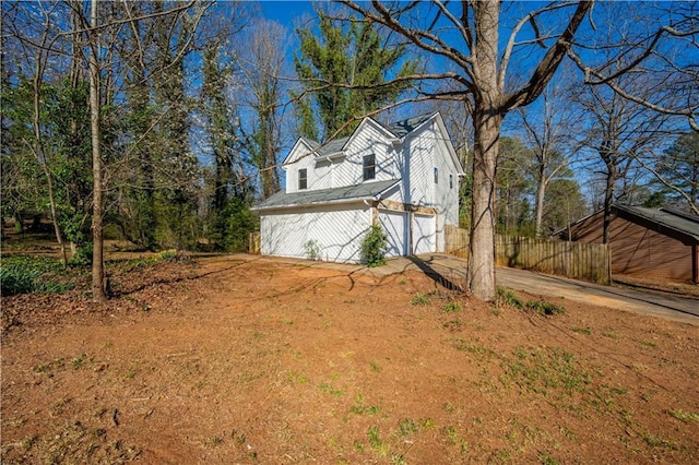 view of side of home with concrete driveway and a garage