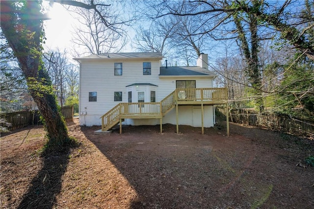 rear view of property with a wooden deck, stairway, fence private yard, and a chimney