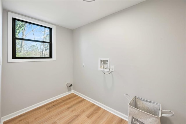 washroom with laundry area, hookup for a washing machine, light wood-style floors, and baseboards