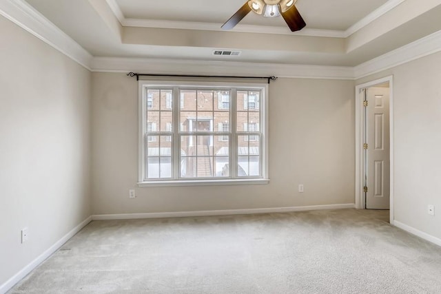 spare room with plenty of natural light, visible vents, a raised ceiling, and carpet flooring