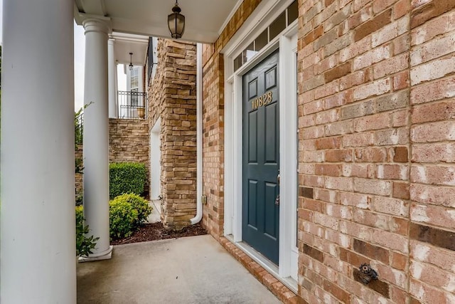 entrance to property with brick siding and a porch