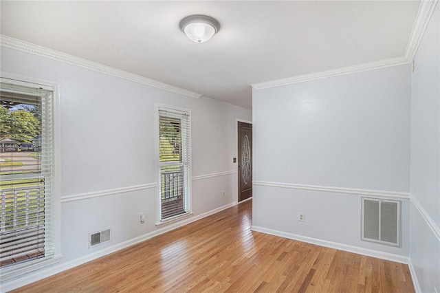 spare room featuring light wood-type flooring and ornamental molding