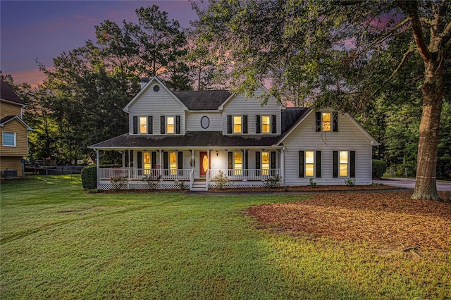 farmhouse inspired home featuring a yard and covered porch