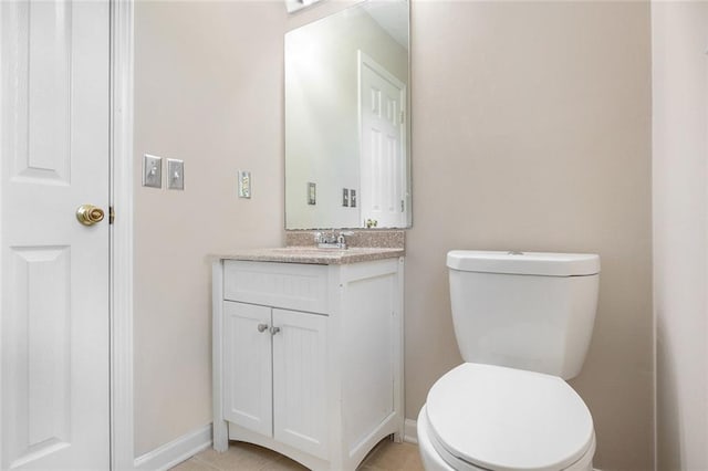 bathroom featuring tile patterned flooring, vanity, and toilet