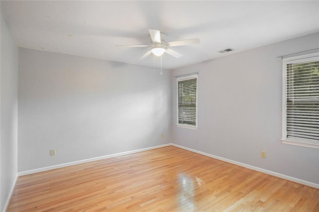 spare room featuring a wealth of natural light, ceiling fan, and light hardwood / wood-style floors