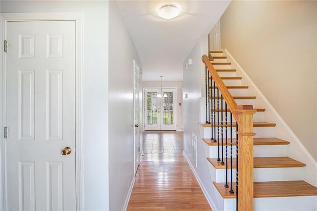 stairs with a chandelier and wood-type flooring