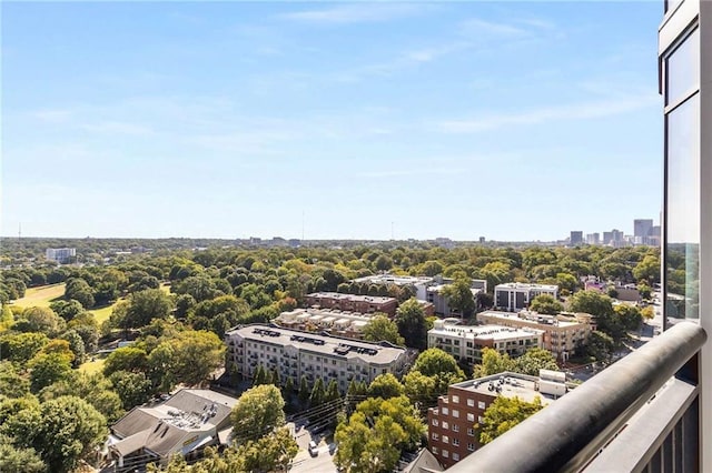 balcony featuring a city view and view of wooded area