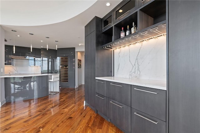 kitchen featuring modern cabinets, a sink, open shelves, dark wood-type flooring, and dark cabinets