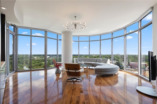 sunroom with floor to ceiling windows, a chandelier, wood finished floors, and recessed lighting