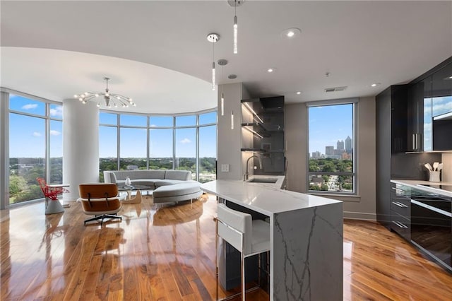 kitchen with dark cabinets, light wood-style floors, a chandelier, open shelves, and modern cabinets