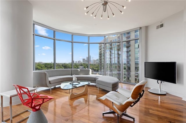living area with a wall of windows, a chandelier, and wood finished floors